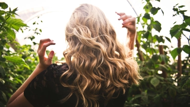 Blondhaarige Frau, Die Zwischen Grünen Pflanzen Steht