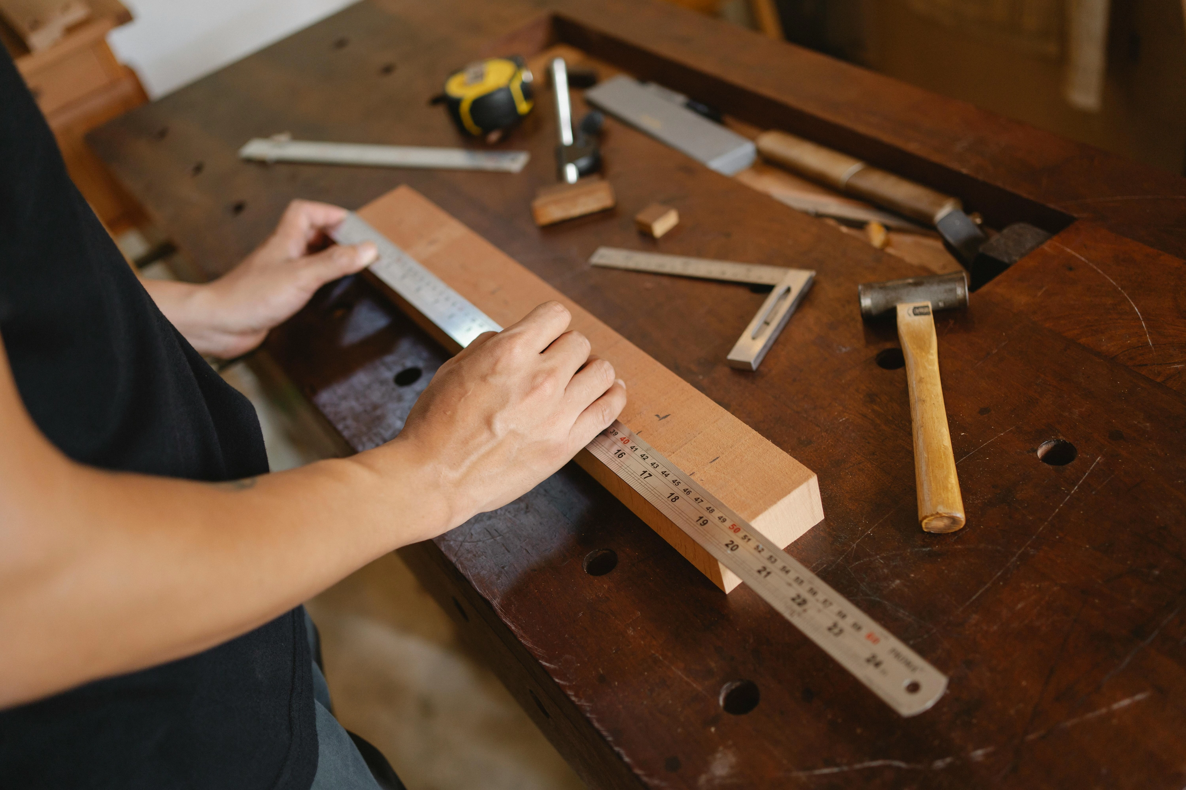 Mann, Der Holzplanke Mit Lineal Misst