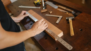 Mann, Der Holzplanke Mit Lineal Misst