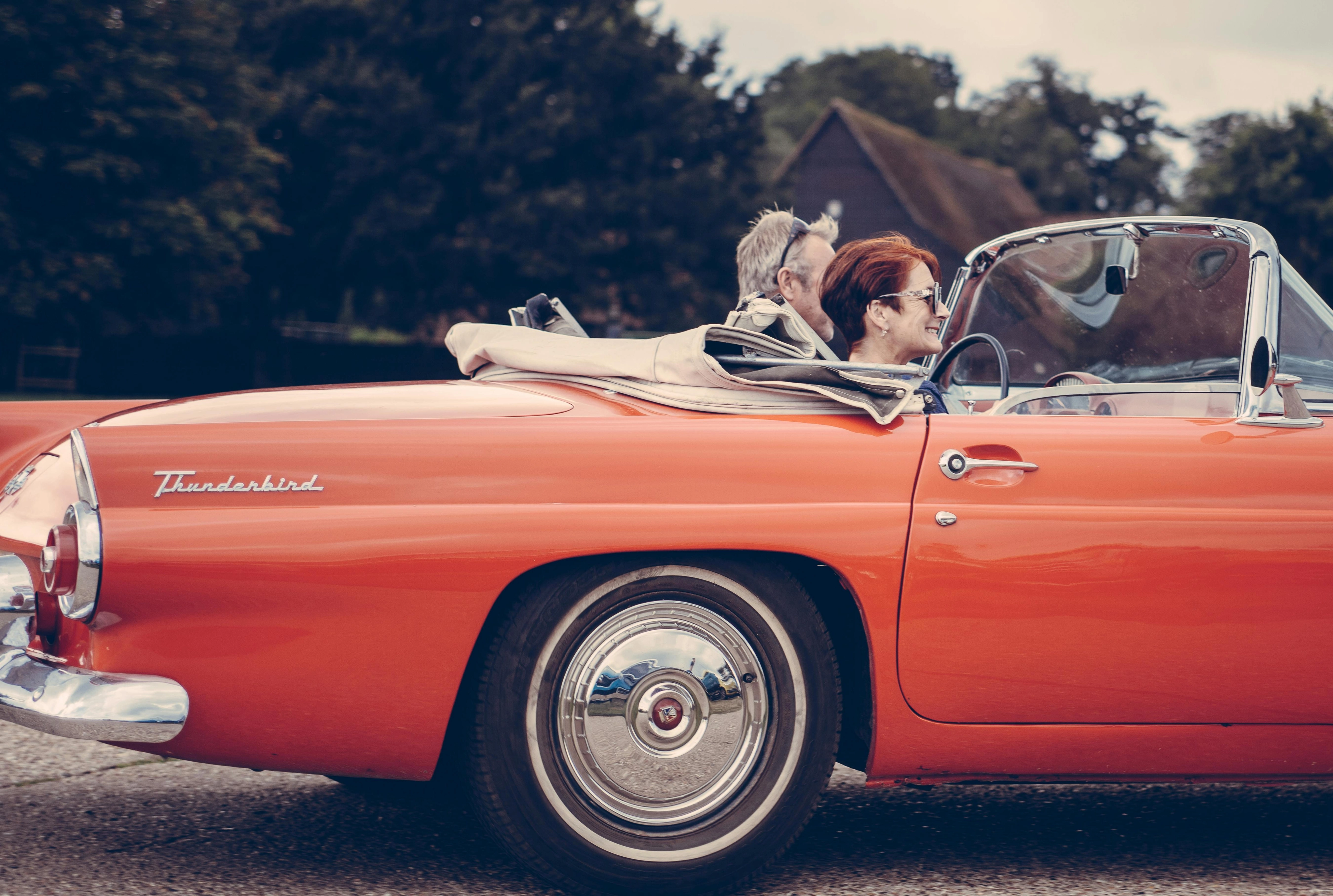 Paar, Das Roten Ford Thunderbird Während Des Tages Reitet