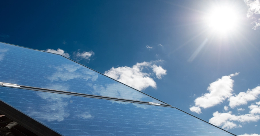 Das Bild zeigt eine PV-Anlage in der Sonne. Mit der Nachfrage nach Klimaanlagen steigt auch der Strombedarf für Kühlung. Klimaanlagen können die Stromüberschüsse aus PV-Strom abschöpfen – durch intelligentes Kühlen gezielt während der Produktionsspitzen.