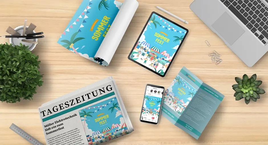 Schreibtisch mit Laptop, Tablet, Smartphone, Zeitung und Flyern mit Motiv eines Sommerfests, umgeben von Stiften, Lineal und Pflanzen.