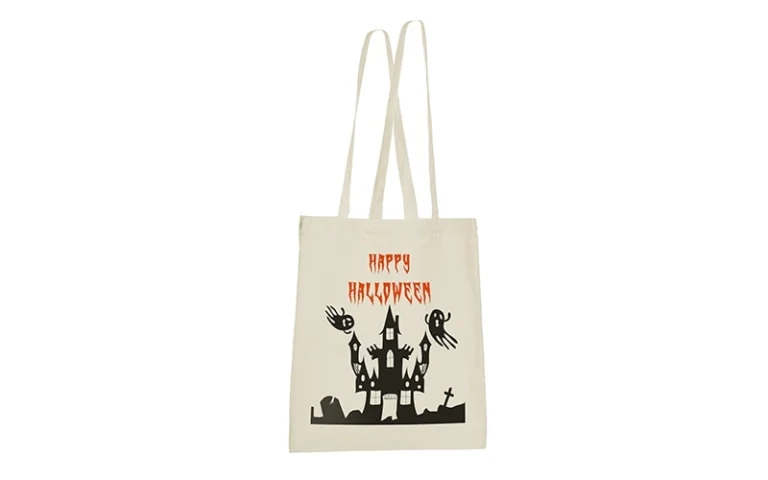 Beige Stofftasche mit dem Schriftzug "Happy Halloween" und einer schwarzen Silhouette eines Spukhauses mit Geistern.
